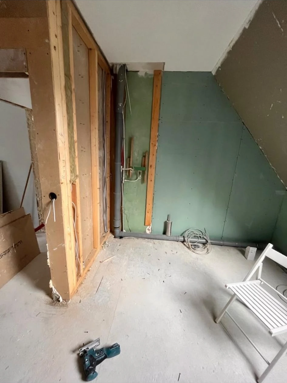 Bad mit offenen Wand- und Installationsbereichen unter der Dachschräge