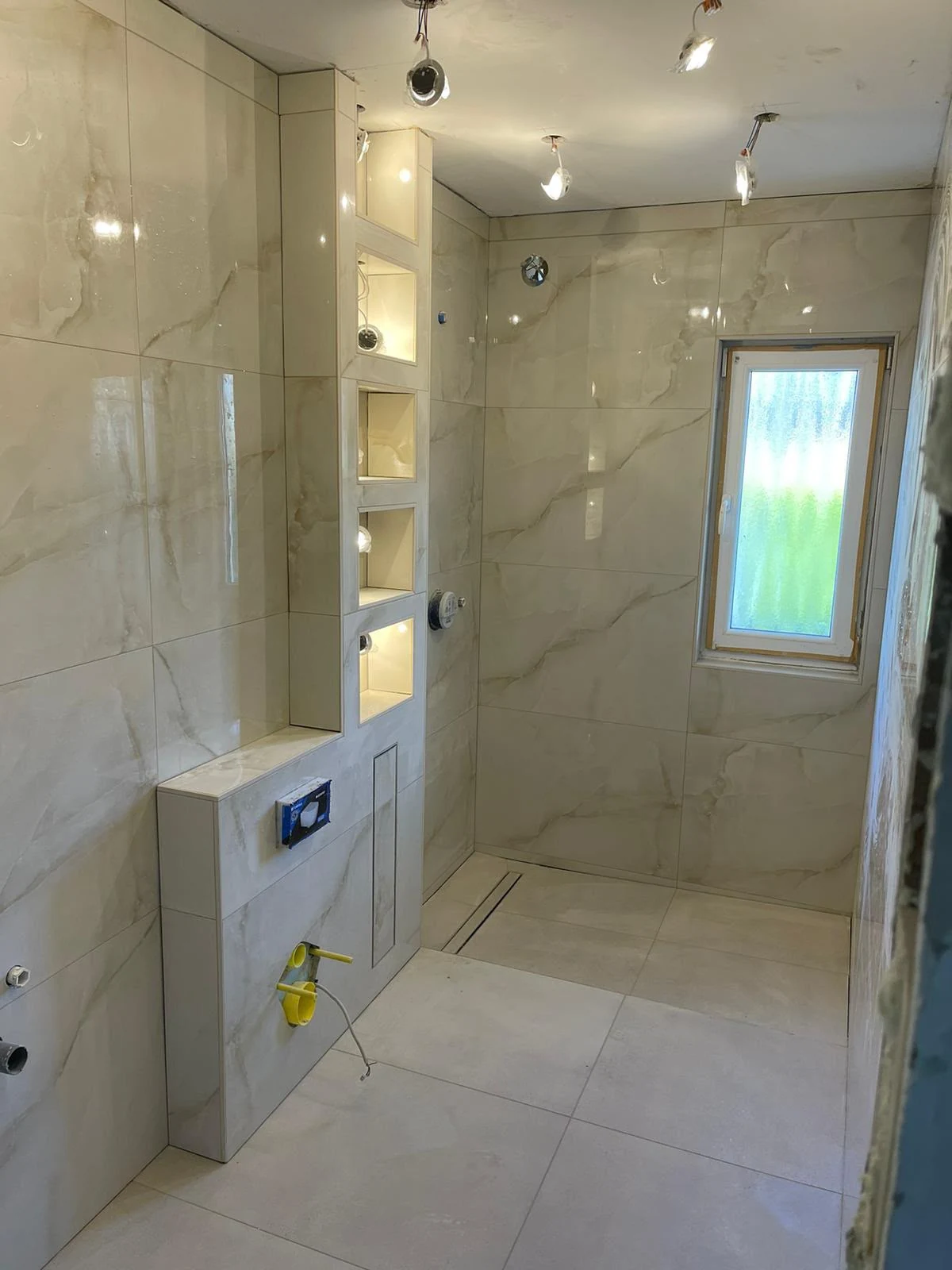 Badezimmer mit fertiggestellten Wand- und Bodenflächen