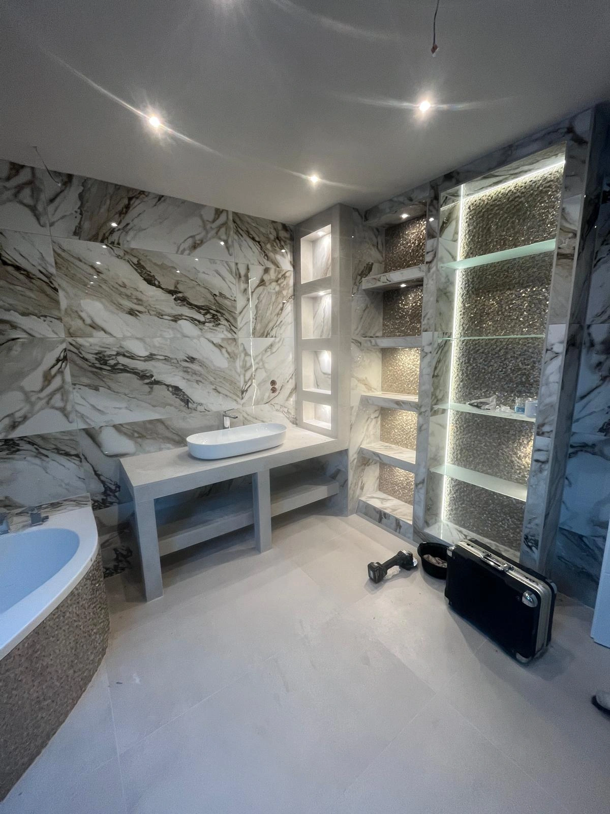Badezimmer mit Waschbecken und beleuchteten Ablagen